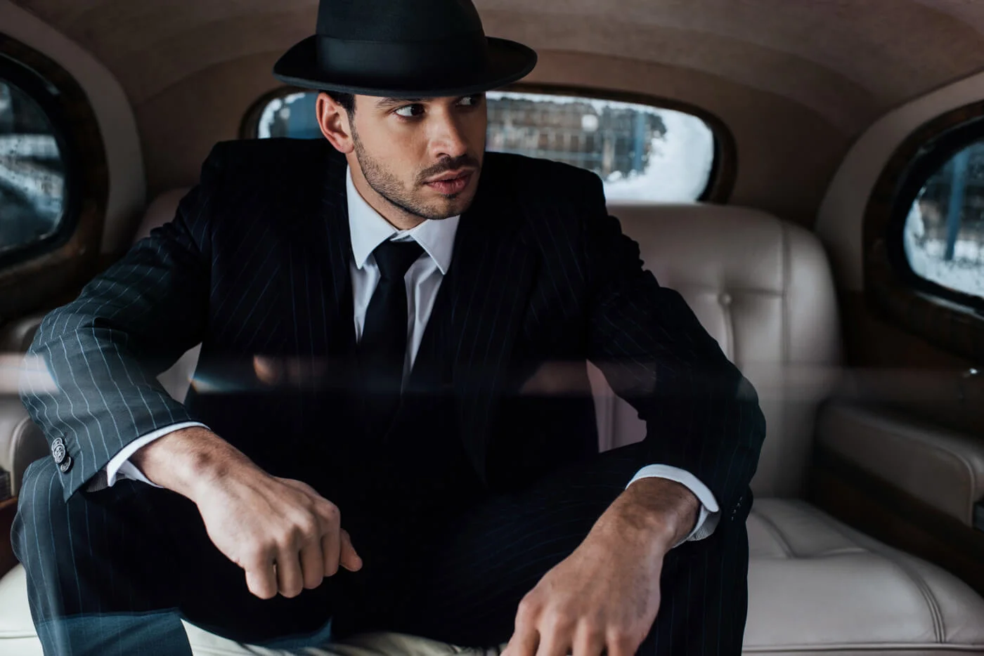 Distinguished elegant man wearing dark tailored suit and a beautiful Domingo Carranza Fur Felt Hats