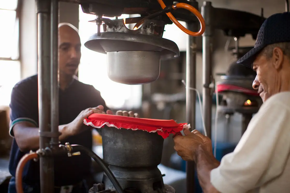 Men with a pressing hat to make Montecristi Panama hats by Domingo Carranza