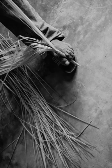 Domingo Carranza Hats working teh toquilla straw with his foot. Before use it for weave a Montecristi Panama Hat