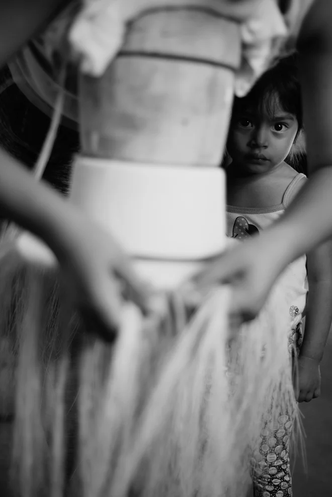 Girl timidly watches her father weaving an extrafine Montecristi Panama Hat in the workshop of master craftsman Domingo Carranza Hats, Pile, Ecuador
